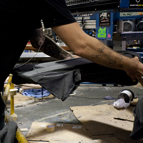 Here our press operator is loading a shirt onto the press so it can be printed.